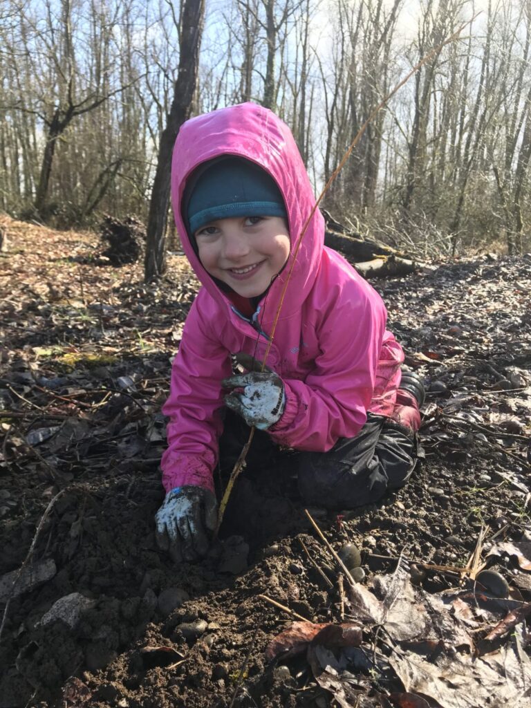 A young volunteer plants a tree on Green Island.